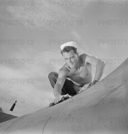 Aviation Machinist's Mate, 2nd Class, Keeping Airplane in Top Condition at Naval Air Base, Corpus Christi, Texas, USA, Howard R. Hollem for Office of War Information, August 1942