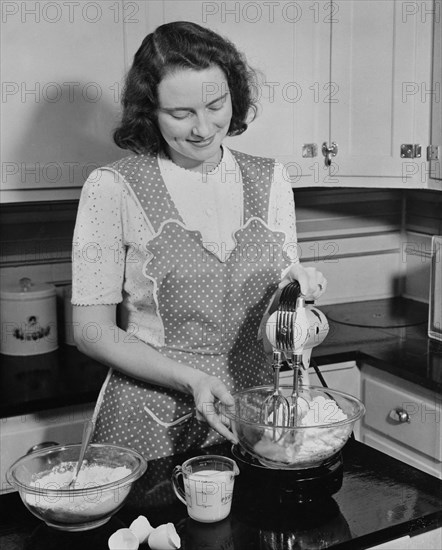 Woman Mixing Cake in Glass Bowl due to Restriction of Metal Products because of Military Needs during World War II, USA, by Office of War Information, January 1943