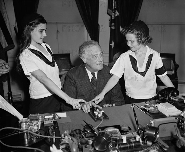 U.S. President Franklin Roosevelt with Two Camp Fire Girls Pressing Telegraph Key to Light Crossed Logs and Flame Lamp in Organization's New National Headquarters in New York City, Washington DC, USA, Harris & Ewing, March 1939