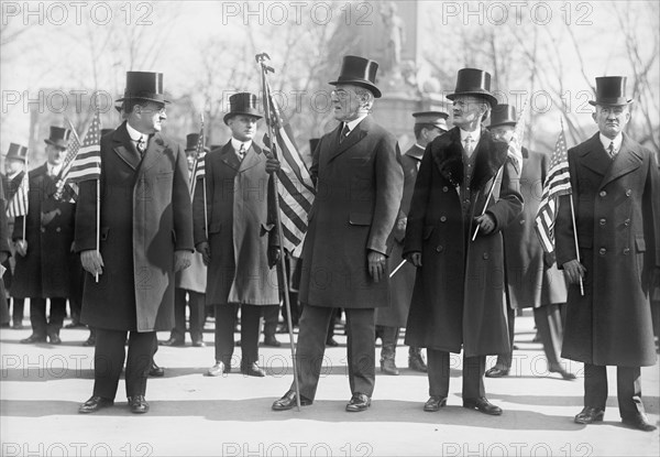 President Woodrow Wilson (center), Vice President Thomas Marshall to Wilson's left, Holding American Flags during Parade Honoring Wilson's Return from Paris Peace Conference, Washington DC, USA, Harris & Ewing, March 1919