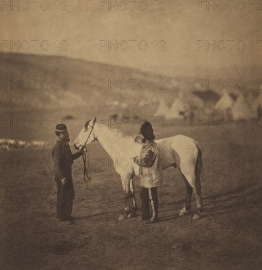 British Colonel George Clarke, Royal Scots Greys, Full-length Portrait, wearing uniform, Standing beside his Wounded Horse, Sultan and another Man with Encampment of Tents in Background, Crimean War, Crimea, Ukraine, by Roger Fenton, 1855