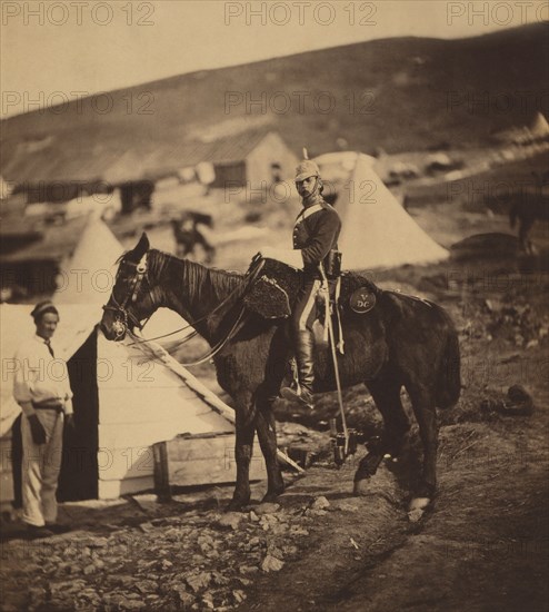 Full-length Portrait of British 5th Dragoon Guards Captain in Uniform, Seated on Horse with another Man Standing at Head of Horse, Tent and Huts in Background, Crimean War, Crimea, Ukraine, by Roger Fenton, 1855