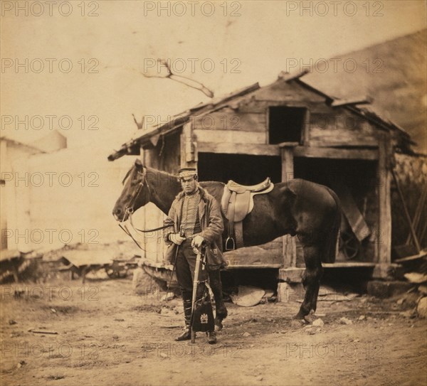 British Captain King, full-length Portrait in Uniform, Standing with Horse, Wooden Huts in Background, Crimean War, Crimea, Ukraine, by Roger Fenton, 1855