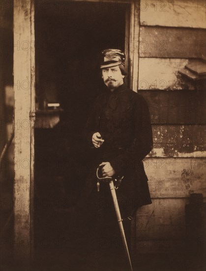 British Captain Francis Baring, Fusilier Guards, Deputy Assistant Quartermaster General, attached to the Light Division, Portrait Standing in Uniform with Hand on Sword at Entrance of Wood Building, Crimean War, Crimea, Ukraine, by Roger Fenton, 1855