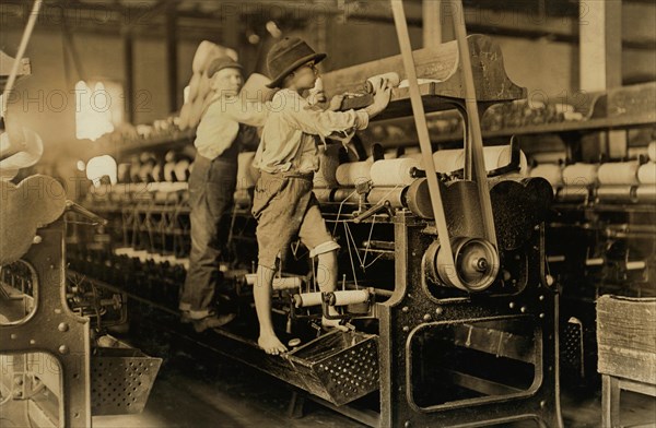 Two Young Boys Climbing on Spinning Frame to Mend Broken Threads and Put Back Empty Bobbins, Bibb Mill No. 1, Macon, Georgia, USA, Lewis Hine for National Child Labor Committee, January 1909