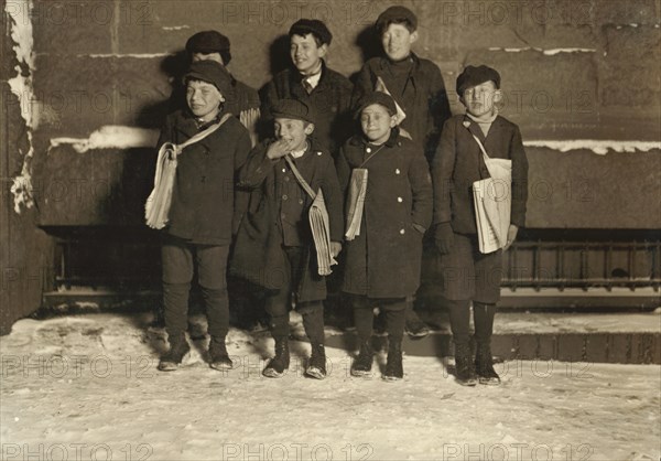 Group of Young Newsies Selling Newspapers at Night, Portrait Standing on Sidewalk in Snow, Hartford, Connecticut, USA, Lewis Hine for National Child Labor Committee, March 1909