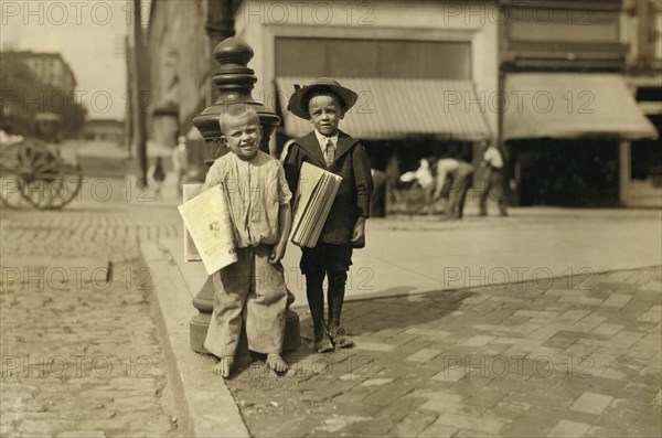 Willie (left), 6 years and Richard Green, 5 years, Young Newsboys, Full-Length Portrait on Sidewalk Selling Newspapers, Richmond, Virginia, USA, Lewis Hine for National Child Labor Committee, June 1911
