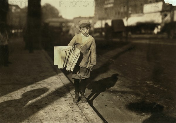 Young Newsboy, (thinks he is) 8 years old, Works Until 6:30 p.m. Every Night, Full-Length Portrait Selling Newspapers on Street, Northampton, Massachusetts, USA, Lewis Hine for National Child Labor Committee, August 1912