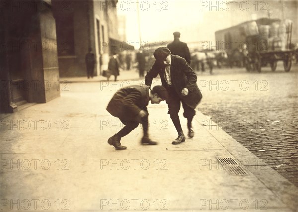 Two Young Boys Pitching Pennies on Sidewalk, Providence, Rhode Island, USA, Lewis Hine for National Child Labor Committee, November 1912