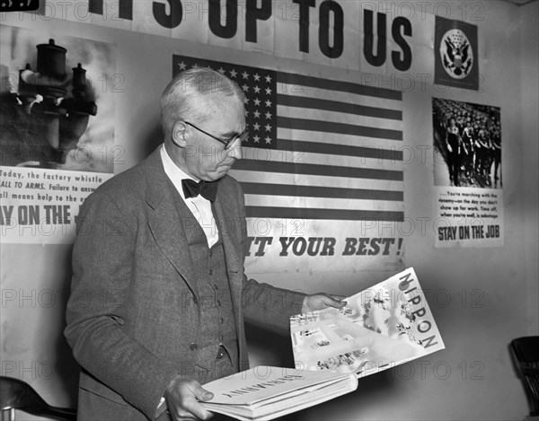 Elmer Davis, Director of Office of War Information, Examining Nazi and Japanese Propaganda Organs at Press Conference to show Material the Axis is Distributing in Neutral Countries, Office of War Information, March 6, 1943
