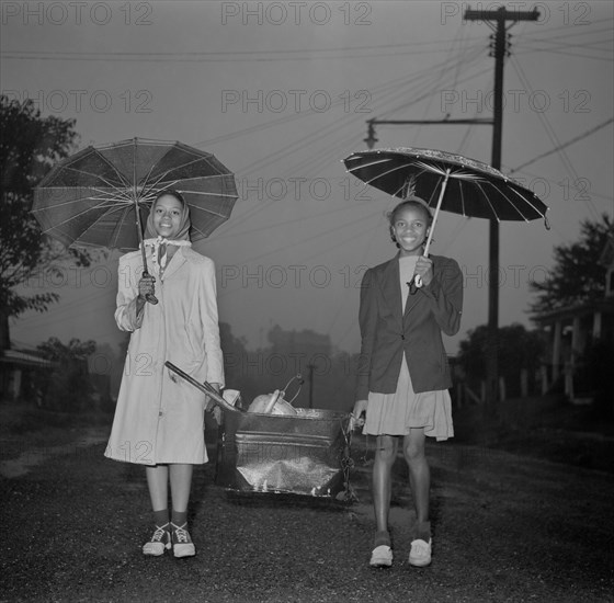 Two Young Girls Carrying Scrap Metal in Rain during Scrap Salvage Campaign, Roanoke, Virginia, USA, Howard Liberman for Office of War Information, October 1942