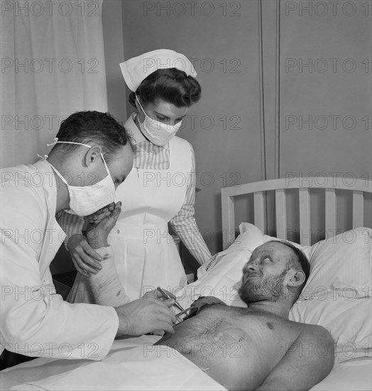 Torpedoed Sailor Receiving Burn Treatment from Doctor and Student Nurse, Susan Petty, Fritz Henle for Office of War Information, November 1942