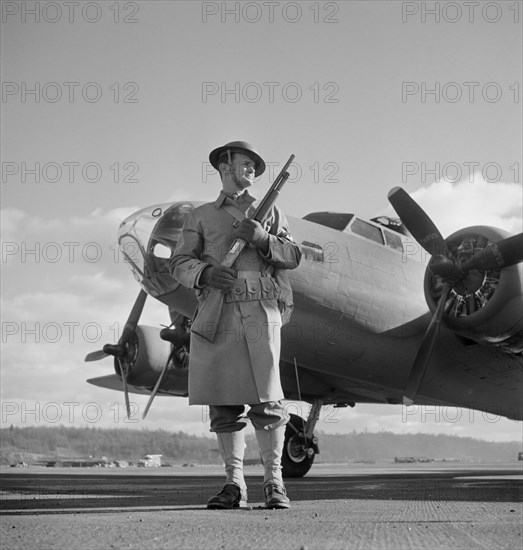 Army Sentry Guarding new B-17F (Flying Fortress) Bombers at Airfield of Boeing Plant, Seattle, Washington, USA, Andreas Feininger for Office of War Information, December 1942