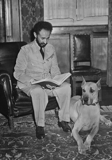 Haile Selassie (1892-1975), Emperor of Ethiopia, Portrait Reviewing Report alongside his Pet Dog, Bull, Upon his Return to Addis Ababa, Ethiopia after Allied Defeat of Italian Fascist Occupation Forces, Office of War Information, 1941