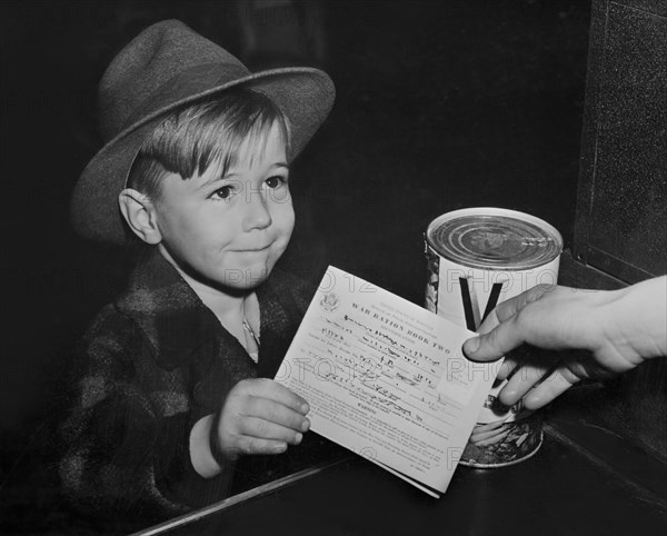 Young Boy with War Ration Book Two at Supermarket, as Children are Being Taught the Facts of Point Rationing during War, Washington DC, USA, Alfred T. Palmer for Office of War Information, February 1943
