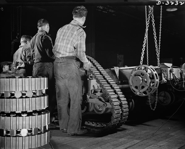 Group of Workers Mounting Tractor Belt on Chassis of the Army's Half-Track Scout Car at Factory Converted to War Production, White Motor Company, Cleveland, Ohio, USA, Alfred T. Palmer for Office of War Information, December 1941