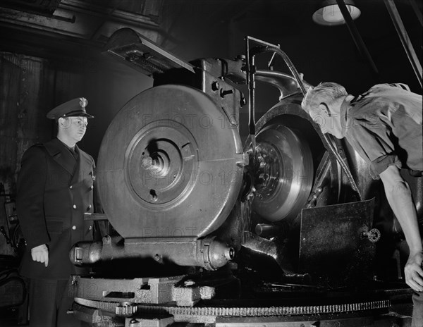 Worker Inspecting Gears of Rear Axles of Army's Half-Track Scout Car at Factory Converted to War Production, White Motor Company, Cleveland, Ohio, USA, Alfred T. Palmer for Office of War Information, December 1941