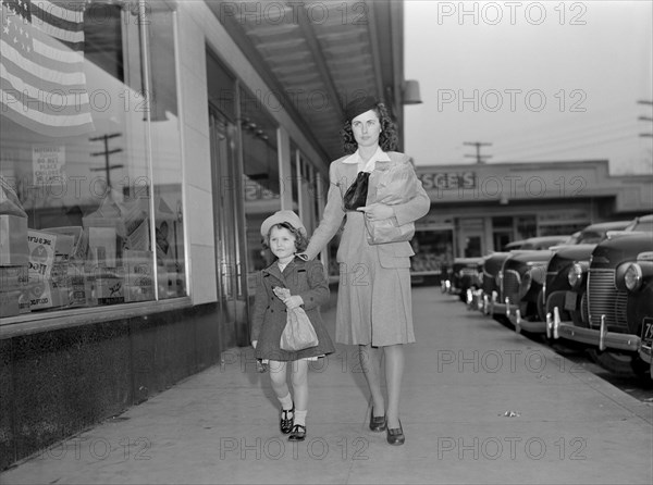 Mother and Daughter Walking Home with Bundles after Shopping While Helping to Conserve Tires on Car or a Merchant's Delivery Truck, as well, during War Effort, Ann Rosener, Office of War Information, February 1942