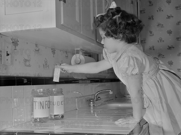 Young Girl Putting Empty Toothpaste Tube into Glass Jar, These Vital Tin and Alloy Metals Conserved by this Procedure will be Converted into Essential Products to Assist the War Effort, Ann Rosener, Office of War Information, February 1942