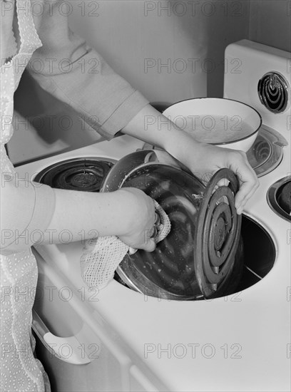 Woman Cleaning Electric Stove with Soap and Water to Keep it Functioning at its Best, as New Stoves and other Durable Goods will be Scarce during War Effort, Ann Rosener, Office of War Information, February 1942