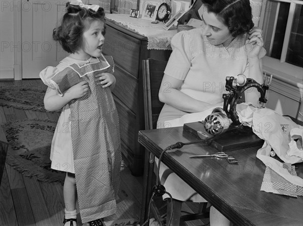 Mother Conserving Clothing by Making Daughter a Playsuit from Old House Dress, as Wool and other Materials are Needed by the Armed Forces, Ann Rosener, Office of War Information, February 1942