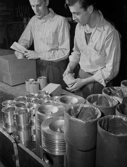 Two Workers Packaging finished Pistons Scheduled to be used in Army Jeeps, Manufactured at Aluminum Factory Converted to War Production, Aluminum Industries, Inc., Cincinnati, Ohio, USA, Alfred T. Palmer for Office of War Information, February 1942