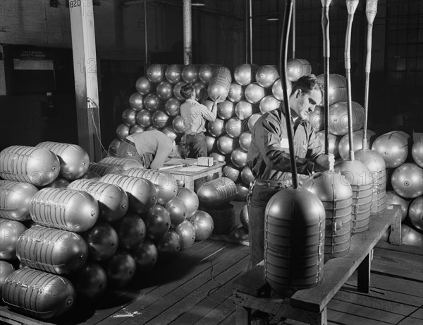 Three Workers Testing and Stacking Shatterproof Oxygen Cylinders for High Altitude Flying Manufactured at Factory Converted to War Production, Firestone Tire and Rubber Company, Akron, Ohio, USA, Alfred T. Palmer for Office of War Information, February 1942