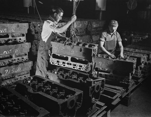 Two Workers Putting Engine Blocks for the Army's Half-Track Scout Car on Assembly Line at Factory Converted to War Production, White Motor Company, Cleveland, Ohio, USA, Alfred T. Palmer for Office of War Information, December 1941