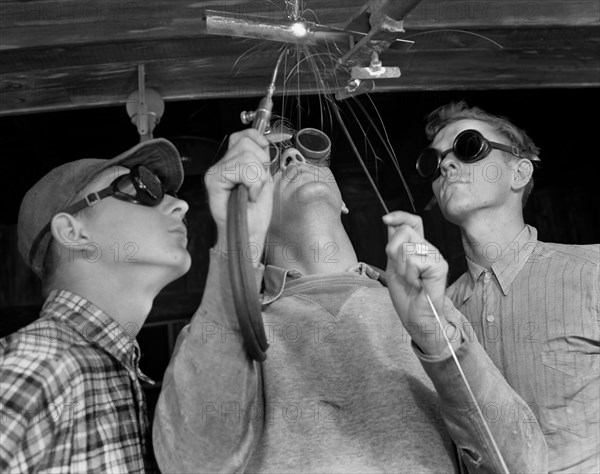 Instructor Training Two Young Men to Weld Aircraft at Vocational School as part of Program to Provide more Workers for War Production for Florida's Pooling Program, De Land, Florida, USA, Howard R. Hollem for Office of War Information, April 1942