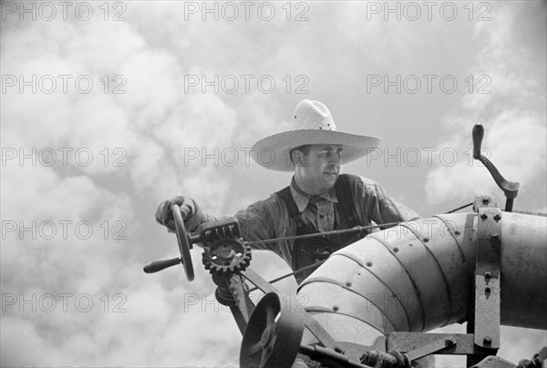 Clover Farmer on Seed Threshing Machine, St. Charles Parish, Louisiana, USA, Carl Mydans for U.S. Resettlement Administration, June 1936