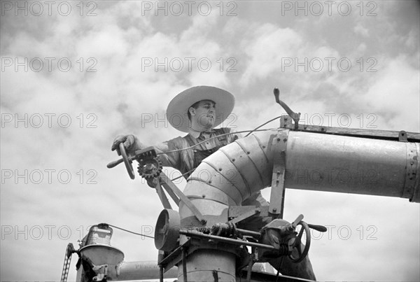 Clover Farmer on Seed Threshing Machine, St. Charles Parish, Louisiana, USA, Carl Mydans for U.S. Resettlement Administration, June 1936