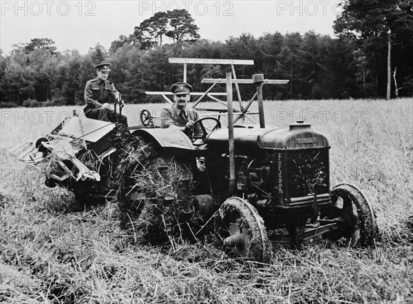 Two Soldiers, Released for Temporary Emergency Farm Work, Operating Tractor and Harvester to cut Ten-Acre Field of Oats during Crop Season, which helped Ease Farm Labor Shortage during World War II, Northern Ireland, UK, U.S. Office of War Information, April 1943