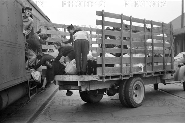 Japanese-Americans and Baggage on Truck Being Loaded on to Train to Owens Valley During Evacuation of Japanese-Americans from West Coast Areas under U.S. Army War Emergency Order, Los Angeles, California, USA, Russell Lee, Office of War Information, April 1942