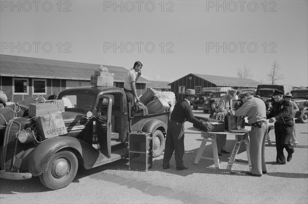 Baggage of Japanese-Americans being Inspected as they Arrive from West Coast Areas under U.S. Army war emergency order, Reception Center, Santa Anita, California, USA, Russell Lee, Office of War Information, April 1942