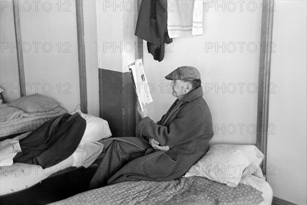 Man Reading on Cot, Homeless Men's Bureau, Sioux City, Iowa, USA, Russell Lee, U.S. Resettlement Administration, December 1936