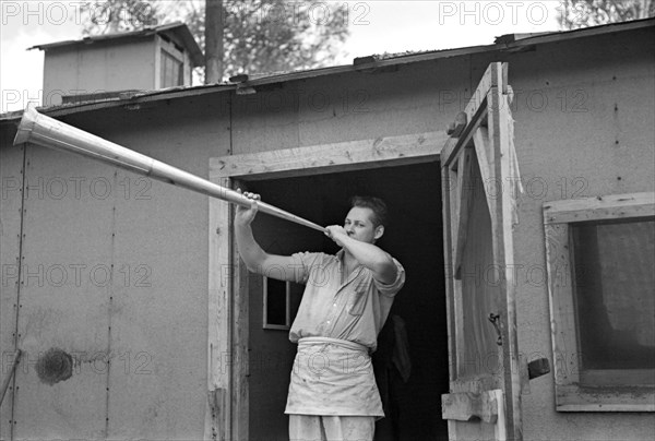 Cook at Lumber Camp Blowing Dinner Horn, near Effie, Minnesota, USA, Russell Lee, U.S. Resettlement Administration, September 1937