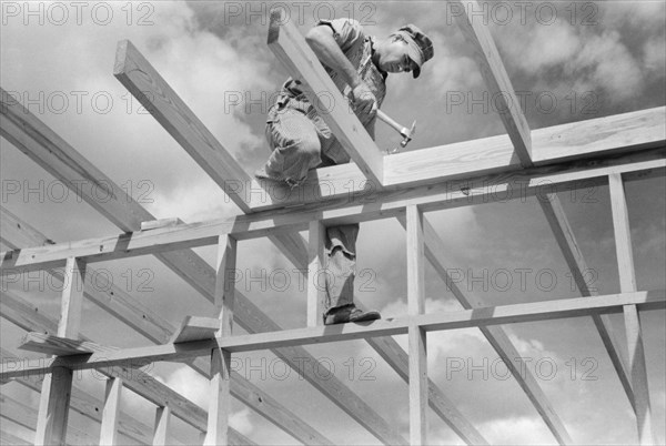 Carpenter Working on Framework of a Unit of a Migrant Camp, Sinton, Texas, USA, Russell Lee, Farm Security Administration, October 1939