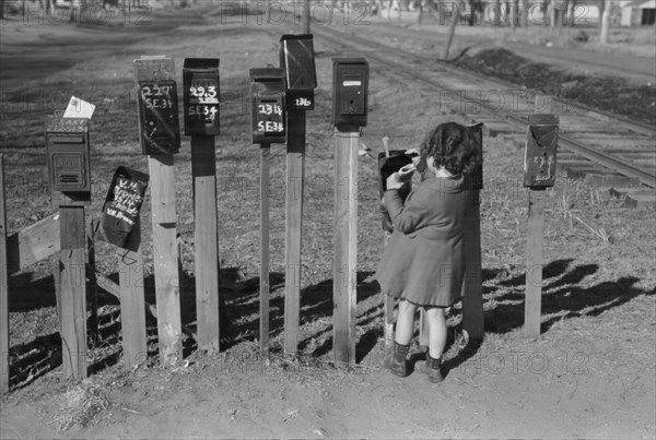 Little Girl Getting Mail from Mailbox, Suburb of Oklahoma City, Oklahoma, USA, Russell Lee, Farm Security Administration, February 1940