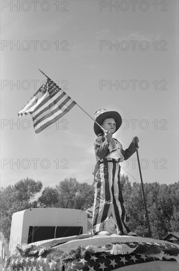 Young Boy in Patriotic Costume Waving American Flag during Fourth of July Parade, Vale, Oregon, USA, Russell Lee, Farm Security Administration, July 1941