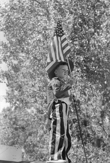 Young Boy in Patriotic Costume Waving American Flag during Fourth of July Parade, Vale, Oregon, USA, Russell Lee, Farm Security Administration, July 1941