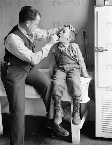 Doctor Examining Boy's Throat, Reedsville, West Virginia, USA, Elmer Johnson, Farm Security Administration, April 1935