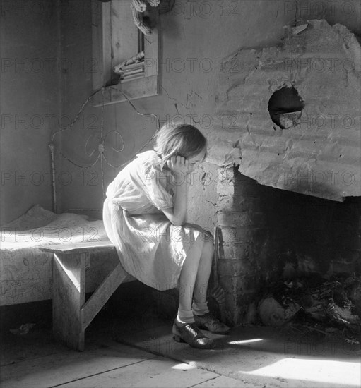 Resettled Farm Child from Taos Junction to Bosque Farms Project, Portrait Sitting near Fireplace, Mills, New Mexico, USA, Dorothea Lange, Farm Security Administration, December 1935