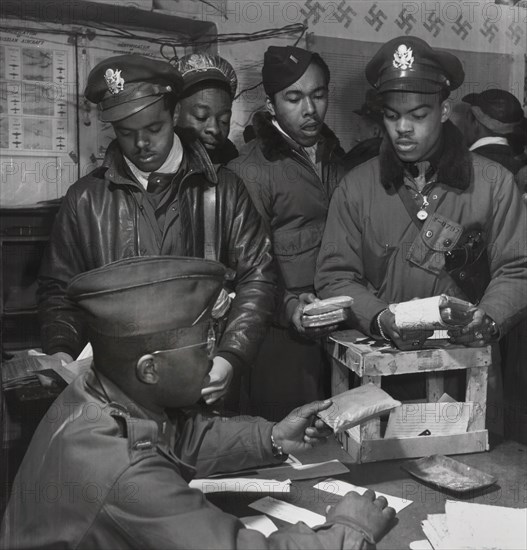 Cyanide "Escape Kits" Being Distributed to Fighter Pilots at Air Base, Seated: Theodore G. Lumpkin, Jr., Standing (left to right): Joseph L. "Joe" Chineworth, Memphis, TN, Class 44-E; Robert C. Robinson, Asheville, NC, Class 44-G; Driskell B. Ponder, Chicago, IL, Class 43-I; Robert W. Williams, Ottumwa, IA, Class 44-E, Ramitelli, Italy, Toni Frissell, March 1945