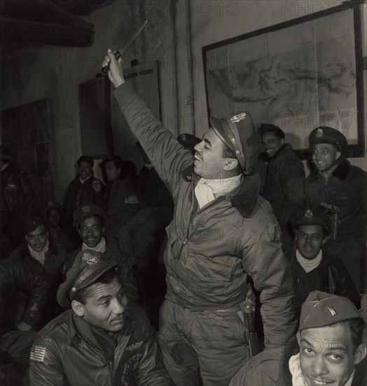 Members of 332nd Fighter Group in Briefing Room, Foreground (left to right) Gentry E. Barnes, Lawrenceville, IL, 44-D; Samuel W. Watts, Jr., New York, NY, 44-E; Wendell M. Lucas, Fairmont Heights, MD, 44-E, Ramitelli, Italy, Toni Frissell, March 1945