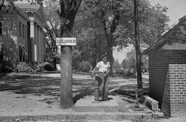 Boy at Drinking Fountain with Sign "Colored" on County Courthouse Lawn, Halifax, North Carolina, USA, John Vachon, Farm Security Administration, April 1938