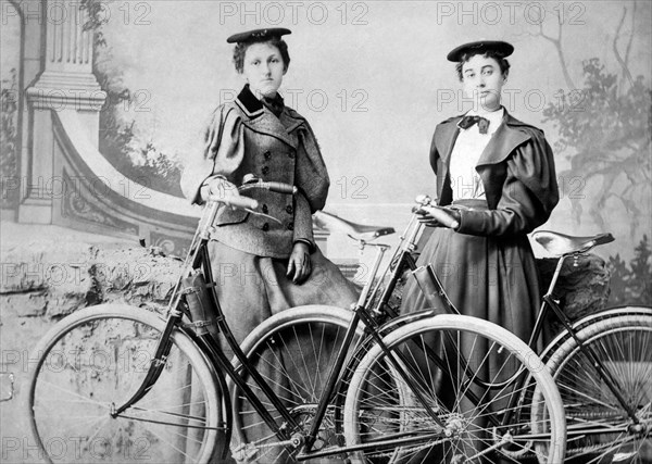 Two Women Standing with Bicycles, circa 1900