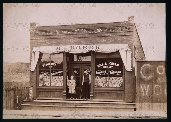 Girl, Dog and Man in Front of Store, 1900