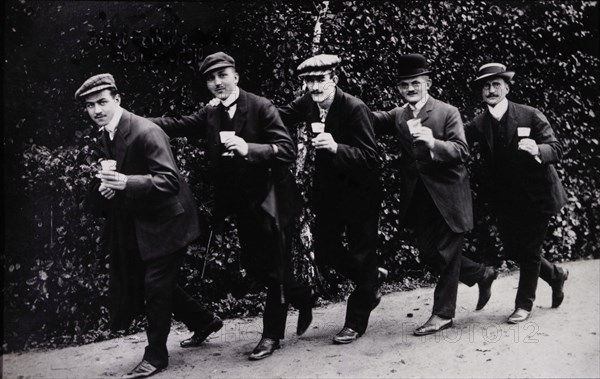 Five Men Holding Beer Glasses While Walking Single File With Hands Touching Shoulders, Germany, 1910