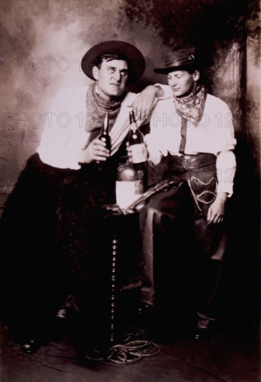 Two Cowboys Seated on Table, Drinking, USA, circa 1905