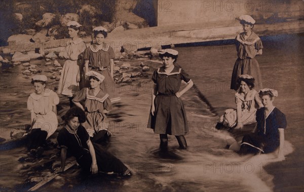 Group of Women in One-Piece Bathing Suits Wading and Sitting in Stream, circa 1907